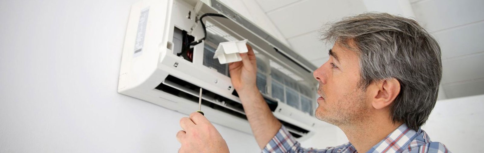 Aircond repair technician diagnosing a unit in KL & Selangor